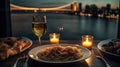 A plate of pasta and wine on a table with a view of the water and a bridge in the background with candles and a glass of wine.