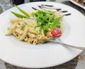 Plate of penne pasta in a creamy sauce, garnished with fresh arugula, cherry tomato, grated cheese and balsamic glaze Royalty Free Stock Photo