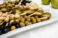 A plate of pickles on a buffet table. Selection of marinated mushrooms, salted cucumbers, olives, mustard in beans Royalty Free Stock Photo