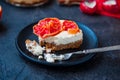 Plate with piece of baked cheesecake with red grapefruit slices and vintage fork on the black stone background with ingredients. S Royalty Free Stock Photo