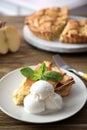 Plate with piece of delicious apple pie and ice cream wooden table Royalty Free Stock Photo