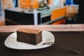 Plate with a piece of delicious homemade chocolate cake on the wooden table in a cafeteria Royalty Free Stock Photo