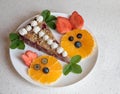 Plate with a piece of wholefood cherry cake. two cute bunny faces made of fruit