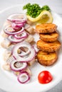 Plate of pieces of herring with fried potato,onion, tomato and lemon. Close up image with selective focus Royalty Free Stock Photo