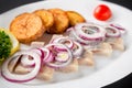 Plate of pieces of herring with fried potato,onion, tomato and lemon. Close up image with selective focus Royalty Free Stock Photo