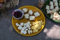 Plate with pieces of tasty cheese on table, closeup