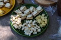 Plate with pieces of tasty cheese on table, closeup