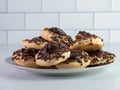 Plate piled high with thumbprint cookies with chocolate frosting and brown sprinkles, delicious, festive baked homemade baked