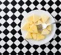 Plate of pineapple slices with a fork on a tablecloth Royalty Free Stock Photo