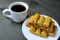 Plate of Pistachio Nuts Baklava Pastries with a Cup of Turkish Coffee Served on Wooden table Royalty Free Stock Photo