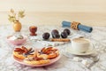Plate with plum tarts with cinnamon and icing sugar on the table, tasty puff pastry dessert.