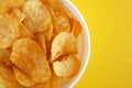 Plate with potato chips on a bright yellow background Royalty Free Stock Photo