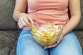 A plate of potato chips and a centimeter tape in the girl`s hands. Junk food. The concept of struggle against excess weight.