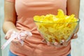 A plate of potato chips and a centimeter tape in the girl`s hands. Junk food. The concept of struggle against excess weight.