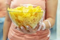 A plate of potato chips and a centimeter tape in the girl`s hands. Junk food. The concept of struggle against excess weight.