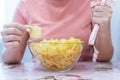 A plate of potato chips and a centimeter tape in the girl`s hands. Junk food. The concept of struggle against excess weight.