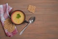 A plate of pumpkin soup on a brown wooden background , cereal loaves on a red napkin.Autumn lunch. Royalty Free Stock Photo