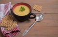 A plate of pumpkin soup on a brown wooden background , cereal loaves on a red napkin. Royalty Free Stock Photo