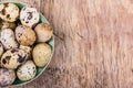 Plate with quail eggs on wooden board. Fresh eggs.