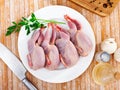 Plate with raw gutted quails and condiments prepared for cooking Royalty Free Stock Photo