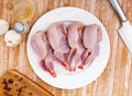 Plate with raw gutted quails and condiments prepared for cooking Royalty Free Stock Photo