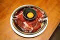 A plate of raw sliced premium wagyu beef with marbled texture, served with organic yolk egg in soy sauce, Prepared for Japanese