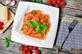 Plate with red heart ravioli with cherry tomato, mozzarella, parmesan and basil on a wood background Royalty Free Stock Photo