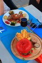 Plate of red tuna with its vegetable garnish and red hamburger in a restaurant