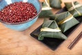 A plate of rice dumplings and a bowl of red beans on a cutting board Royalty Free Stock Photo