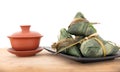 A plate of rice dumplings and a bowl of tea on a cutting board in front of white background Royalty Free Stock Photo