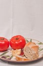 Plate with a ripe, local, freshly picked, beef steak tomatoes with a chuck of aged cheese, a section of freshly baked baguette Royalty Free Stock Photo