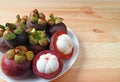 Plate of Ripe Mangosteen Fruits with Pair of Cut Fruits Showing White Delectable Flesh