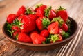 Plate with ripe red strawberries on wooden table Royalty Free Stock Photo