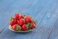 Plate with ripe red strawberries on wooden table Royalty Free Stock Photo