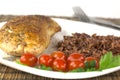 Plate with roast turkey with brown and red rice and whole cherry