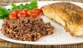 Plate with roast turkey with brown and red rice and whole cherry