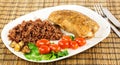 Plate with roast turkey with brown and red rice and whole cherry