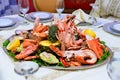 Plate of roasted tiger prawns and octopus pieces with fresh leek, salad, peppers, lemon, bread, pesto sauce Royalty Free Stock Photo