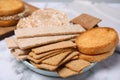 Plate of rye crispbreads, rice cakes and rusks on white marble table Royalty Free Stock Photo