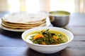 plate of saag aloo beside a stack of chapatis Royalty Free Stock Photo