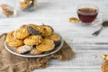 A plate with sackcloth cookies. Glass cup of tea on a saucer. White wood background Royalty Free Stock Photo