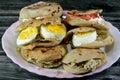 A Plate with Sandwiches of Feta white cheese with slices of tomatoes, traditional plain tahini halva or Halawa Tahiniya and slices