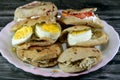 A Plate with Sandwiches of Feta white cheese with slices of tomatoes, traditional plain tahini halva or Halawa Tahiniya and slices