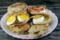 A Plate with Sandwiches of Feta white cheese with slices of tomatoes, traditional plain tahini halva or Halawa Tahiniya and slices