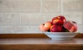 A plate with Saturn peaches on a wooden table in the kitchen. Peaches on a kitchen table against a brick wall background with copy Royalty Free Stock Photo