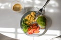 Plate with scrambled eggs, arugula, tomato, whole wheat toast with avocado, cup of coffee on table Royalty Free Stock Photo