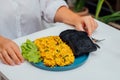 Plate of scrambled tofu eggs paired with charcoal bread, modern vegan breakfast