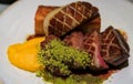 Plate of seared duck breast and foie gras with a side of potato gratin and sweet potato puree at a restaurant in Porto