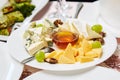 A plate with a set of different cheeses: Mazda, Parmesan, Blue Cheese, served with fruits. Royalty Free Stock Photo