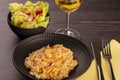 Plate of shrimp risotto, lettuce salad and cherry tomatoes and a glass of white wine Royalty Free Stock Photo